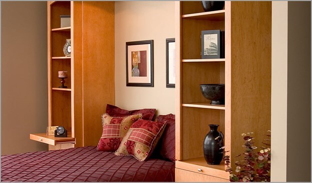 Murphy bed surrounded with cabinets, shelves and drawers